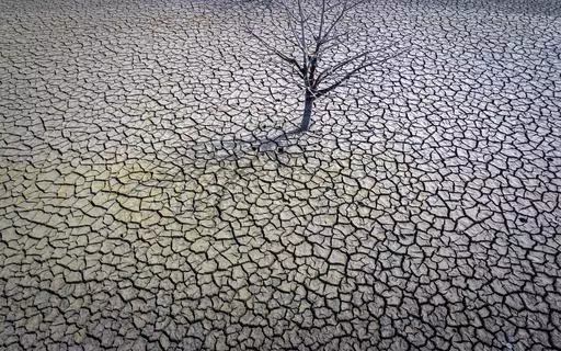 The cracked earth of the Sau reservoir is visible north of Barcelona, Spain, March 20, 2023. Earth last year shattered global annual heat records, the European climate agency said Tuesday, Jan. 9, 2024. (AP Photo/Emilio Morenatti, File)