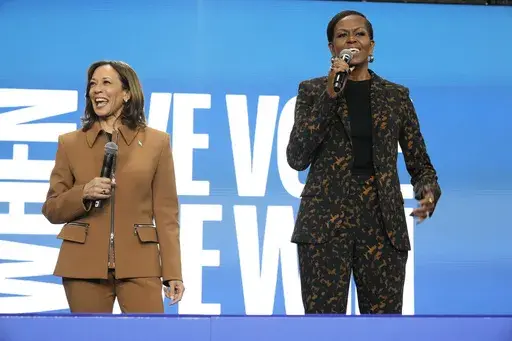 Former first lady Michelle Obama speaks as Democratic presidential nominee Vice President Kamala Harris listens at the overflow space of a campaign rally at the Wings Event Center in Kalamazoo, Mich. (AP Photo/Jacquelyn Martin)
