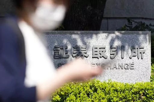 A person walks near the Tokyo Stock Exchange building Thursday, April 27, 2023, in Tokyo. Asian stock markets were mixed Friday after Wall Street sank on worries about the health of U.S. banks that are under pressure from interest rate hikes. (AP Photo/Eugene Hoshiko)