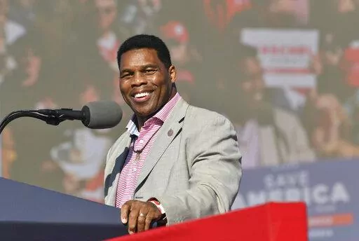 Herschel Walker, front-runner for the party's U.S. Senate nominee, speaks during a rally for Georgia GOP candidates at Banks County Dragway in Commerce, Ga., Saturday, March 26, 2022. In his run for U.S. Senate in Georgia, former football great Herschel Walker has gone to great lengths so far to dodge tough questions. The GOP candidate does not widely publicize his campaign stops and limits his appearances mostly to conservative news outlets and friendly audiences. Earlier this month, he skipped