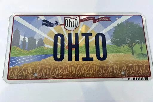 Ohio Gov. Mike DeWine on Thursday, Oct. 21, 2021, unveiled the new "Sunrise in Ohio" license plate in Columbus, Ohio. A backwards image of the Wright Flyer that appeared on the initial version of Ohio’s new license plate was added to the design early and never changed or questioned throughout the approval process, according to public records obtained by The Associated Press. The error was fixed only after the public unveiling in October drew attention to it. (Jessie Balmert/The Cincinnati Enqu