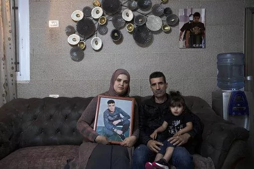 Maysoon, left, and Saleh Manasra, parents of Ahmad Manasra, who has been imprisoned by Israel since he was 13 when he was was convicted of attempted murder and sentenced to nine and a half years in prison, after his older cousin stabbed two Israelis, pose for a portrait with their daughter, Sham, in their home in east Jerusalem, Tuesday, Nov. 8, 2022. The 13 year-old Palestinian boy, whose case became a lighting rod for the Israeli-Palestinian conflict seven years ago, is now a man languishing i
