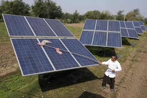 Farmer Pravinbhai Parmar cleans a solar panel installed at a farm in Dhundi village of Kheda district in western Indian Gujarat state, India, Friday, Jan. 13, 2023. The Indian government will not consider any proposals for new coal plants for the next five years and focus on growing its renewables sector, according to an updated national electricity plan released Wednesday evening. (AP Photo/Ajit Solanki, File)