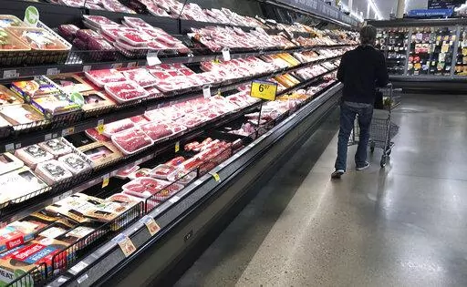 In this May 10, 2020 file photo, a shopper pushes his cart past a display of packaged meat in a grocery store in southeast Denver. Prices at the wholesale level fell from June to July, the first month-to-month drop in more than two years and a sign that some of the U.S. economy's inflationary pressures cooled last month. Thursday’s report from the Labor Department showed that the producer price index — which measures inflation before it reaches consumers — declined 0.5% in July. (AP Photo/