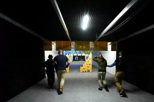 Instructors train Ukrainian national at a shooting range in Brno, Czech Republic, Sunday April 10, 2022. Since Russia launched its brutal attack against Ukraine, Ukrainians living across Czech Republic have been arriving in the second largest Czech city of Brno. They have come for courses designed to teach them skills to safely handle lethal rifles while being able to inflict damage on their enemy. (AP Photo/Petr David Josek)
