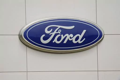 The Ford logo is seen on signage at a Ford dealership, Tuesday, July 27, 2021. The National Highway Traffic Safety Administration is investigating a Ford Motor Co. recall of more than a quarter-million Explorer SUVs in the U.S. after receiving complaints about repairs intended to prevent the vehicles from unexpectedly rolling away even while placed in “park” gear. (AP Photo/Gerry Broome, File)