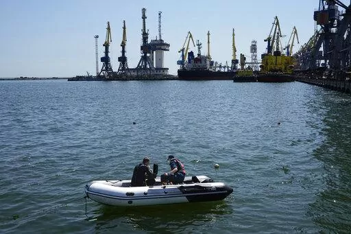 Servicemen of Donetsk People's Republic Emergency Ministry work to defuse a Ukrainian mine in an area of the Mariupol Sea Port, on April 29, 2022. Shipping companies are not rushing to export millions of tons of trapped grain out of Ukraine, despite a breakthrough deal to provide safe corridors through the Black Sea. That is because the waters are mined, ship owners are still assessing the risks and many still have questions over how the deal will unfold. This photo was taken during a trip organ