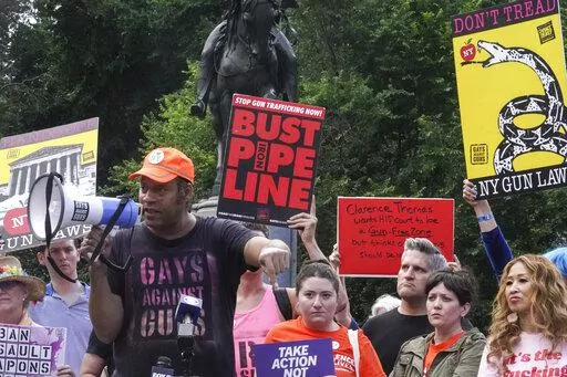 Jay Walker, third from left, co-founder of Gays Against Guns, speaks into a megaphone during a rally against the Supreme Court decision striking down New York's gun law, Thursday, June 23, 2022, in New York.  When the U.S. Supreme Court struck down New York’s tight restrictions on who can carry a handgun, condemnation erupted from liberal leaders and activists. (AP Photo/Bebeto Matthews)