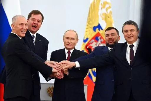 From left, Moscow-appointed head of Kherson Region Vladimir Saldo, Moscow-appointed head of Zaporizhzhia region Yevgeny Balitsky, Russian President Vladimir Putin, center, Denis Pushilin, leader of self-proclaimed of the Donetsk People's Republic and Leonid Pasechnik, leader of self-proclaimed Luhansk People's Republic pose for a photo during a ceremony to sign the treaties for four regions of Ukraine to join Russia, at the Kremlin in Moscow, on Sept. 30, 2022. (Grigory Sysoyev, Sputnik, Kremlin