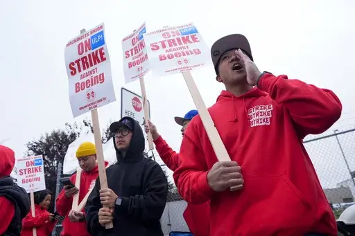 Boeing wing mechanic lead Lee Lara, who has worked for the company for 16 years, yells in response to honks from passing drivers as workers wave picket signs while striking after union members voted to reject a contract offer, Sunday, Sept. 15, 2024, near the company's factory in Everett, Wash. (AP Photo/Lindsey Wasson)