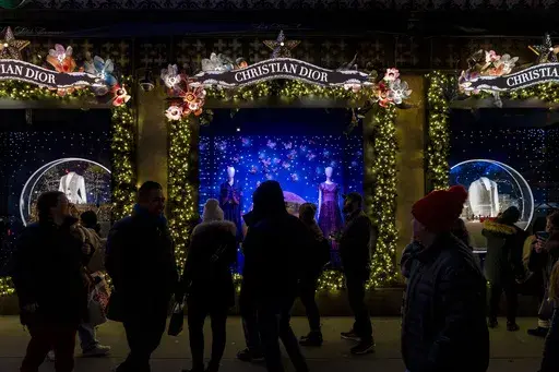 Shoppers and pedestrians walk past a window display at Saks Fifth Avenue in New York, Dec. 14, 2023. (AP Photo/Peter K. Afriyie, File)