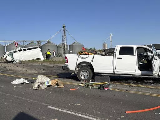 In this photo provided by KIFI Local News 8, a pickup truck crashed into a passenger van on U.S. Highway 20, Saturday, May 18, 2024, in Idaho Falls, Idaho. State police say the accident happened early Saturday morning when a pickup crossed the centerline on U.S. Highway 20 and fatally hit a passenger van. (Jeff Roper/KIFI Local News 8 via AP)