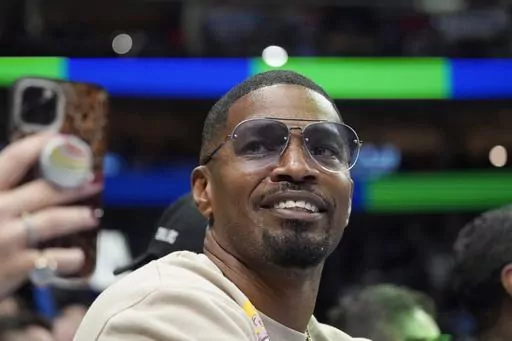 Jamie Foxx smiles during an NBA basketball game between the Washington Wizards and Dallas Mavericks in Dallas, Saturday, Nov. 27, 2021. Academy Award winning actor, Grammy winning singer and comedian says he “went to hell and back” but is recovering from an undisclosed medical condition. Foxx made his first public comments in an Instagram message posted on Friday, July 21, 2023 after being hospitalized in April. (AP Photo/LM Otero, File)