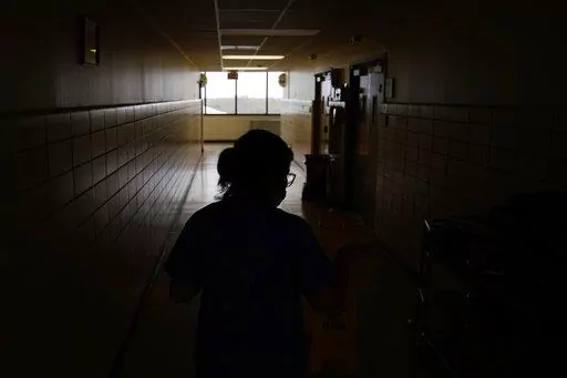 A chief nursing officer walks down a hallway in the recently reopened emergency room at a hospital  in Houma, La., on Friday, Sept. 3, 2021. Patients worried about getting smacked with an unexpected bill after emergency care gained a layer of protection in January 2022 from a new federal law. The No Surprises Act prevents doctors or hospitals in many situations from billing insured patients higher rates because the care providers are not in their insurer’s coverage network. (AP Photo/John Loch