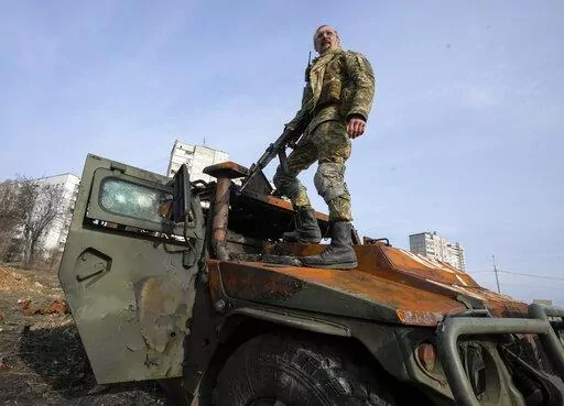 A Ukrainian soldier stands a top a destroyed Russian APC after recent battle in Kharkiv, Ukraine, on March 26, 2022. With Russia continuing to strike and encircle urban populations, from Chernihiv and Kharkiv in the north to Mariupol in the south, Ukrainian authorities said Saturday that they cannot trust statements from the Russian military Friday suggesting that the Kremlin planned to concentrate its remaining strength on wresting the entirety of Ukraine's eastern Donbas region from Ukrainian 