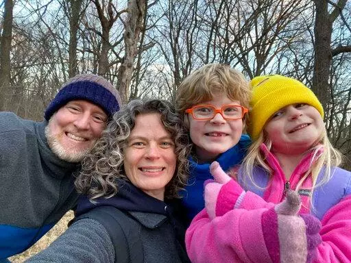 In this 2022 provided by the Schmidt and Morehead families, Tyler Schmidt, left, and his wife Sarah pose with their son Arlo and daughter Lula, right, while hiking near Cedar Falls, Iowa. Police said Saturday, July 23, 2022, the Iowa couple and their 6-year-old daughter were fatally shot while camping in a state park by a man from Nebraska who later turned the gun on himself. The couple's 9-year-old son survived.  (Courtesy of the Schmidt and Morehead families)