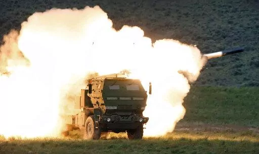 In this May 23, 2011, file photo a launch truck fires the High Mobility Artillery Rocket System (HIMARS) produced by Lockheed Martin during combat training in the high desert of the Yakima Training Center, Wash. U.S. officials will send another $450 million in military aid to Ukraine, including some additional medium-range rocket systems. The latest package will include a number of High Mobility Artillery Rocket Systems, or HIMARS. (Tony Overman/The Olympian via AP, File)