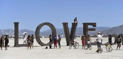 Participants walk around at the Burning Man festival on the Black Rock Desert of Gerlach, Nev., on Aug. 27, 2014. Burning Man organizers don't foresee major changes in 2024 thanks to a hard-won passing grade for cleaning up this year's festival. (Andy Barron/The Reno Gazette-Journal via AP, File)