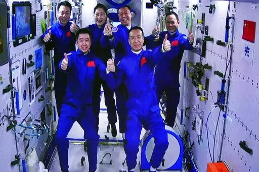 In this photo released by Xinhua News Agency, an image captured off a screen at the Jiuquan Satellite Launch Center in northwest China shows the Shenzhou-15 and Shenzhou-14 crew taking a group picture with their thumbs up after a historic gathering in space on Wednesday, Nov. 30, 2022. Three Chinese astronauts docked early Wednesday with their country's space station, where they will overlap for several days with the three-member crew already onboard and expand the facility to its maximum size. 