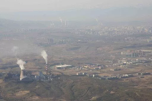 Smoke and steam rise from towers at the coal-fired Urumqi Thermal Power Plant as seen from a plane in Urumqi in western China's Xinjiang Uyghur Autonomous Region on April 21, 2021. China is promoting coal-fired power as the ruling Communist Party tries to revive a sluggish economy, prompting warnings that Beijing is setting back efforts to cut climate-changing carbon emissions from the biggest global source. (AP Photo/Mark Schiefelbein, File)