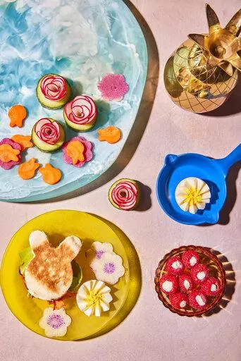 This image released by Harvest shows a breakfast recipe for carrot bacon along with watermelon radish and eggs in the shape of flowers and raspberry parfait bites from the book "Dictator Lunches: Inspired Meals That Will Compel Even the Toughest of Children" by Jenny Mollen. (Lauren Volo/Harvest via AP)