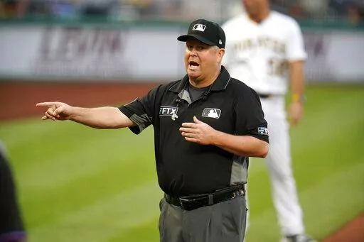 Umpire crew chief Todd Tichenor announces the outcome of a play review during a baseball game between the Pittsburgh Pirates and the Miami Marlins in Pittsburgh, Saturday, July 23, 2022. The notion of hearing a mic'd-up ump's voice explaining something feels oddly revolutionary, even after nearly an entire season of hearing it off and on. (AP Photo/Gene J. Puskar)