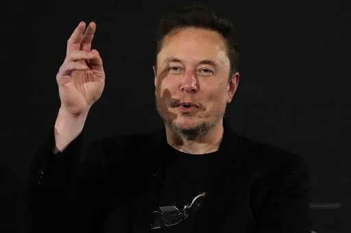 Elon Musk, owner of social media platform X, gestures during an event with Britain's Prime Minister Rishi Sunak in London on Nov. 2, 2023. IBM has stopped advertising on X after a report said its ads were appearing alongside material praising Adolf Hitler and Nazis. (AP Photo/Kirsty Wigglesworth, Pool, File)