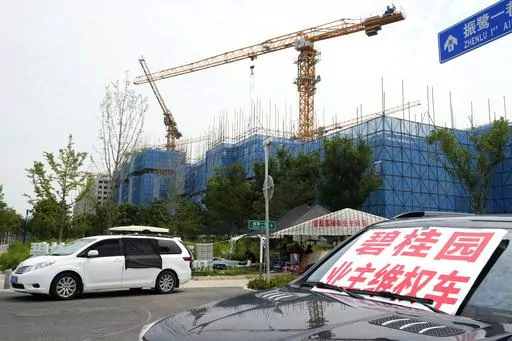 A car with a sign that reads, "Country Garden homeowners rights protections car," is parked near homeowners camping outside the Country Garden One World City project under construction on the outskirts of Beijing, Thursday, Aug. 17, 2023. China's government is trying to reassure jittery homebuyers after the major real estate developer missed a payment on its multibillion-dollar debt, reviving fears about the industry's shaky finances and their impact on the struggling Chinese economy. (AP Photo/