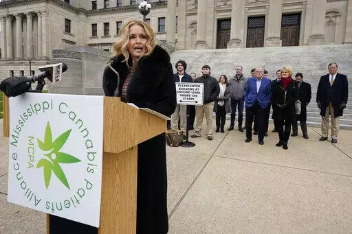 Angie Calhoun, CEO and founder of The Mississippi Cannabis Patients Alliance and a number of members, board members and advocates for medical marijuana, addresses reporters at the Mississippi State Capitol, in Jackson, to listen to their plea to the Legislature to pass the Mississippi Medical Cannabis Act "as is" on the first day of the new legislative session, Tuesday, Jan. 4, 2022. (AP Photo/Rogelio V. Solis)
