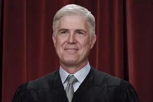 Associate Justice Neil Gorsuch joins other members of the Supreme Court as they pose for a new group portrait, at the Supreme Court building in Washington, Friday, Oct. 7, 2022. Gorsuch called emergency measures taken during the COVID-19 crisis that killed more than 1 million Americans perhaps “the greatest intrusions on civil liberties in the peacetime history of this country.” The 55-year-old conservative justice pointed to orders closing schools, restricting church services, mandating vac