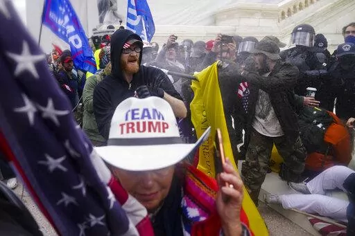 In this Jan. 6, 2021, file photo, insurrections loyal to President Donald Trump try to break through a police barrier at the Capitol in Washington. The Department of Justice is prosecuting those who violently stormed the Capitol. More than 870 people have been charged and more than 400 convicted. (AP Photo/John Minchillo, File)
