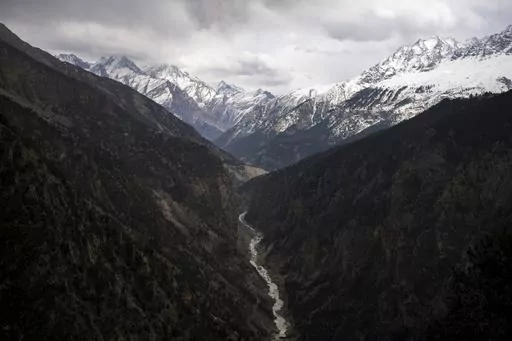 The Sutlej River flows in the valley below the tall snowy peaks in the Kinnaur district of the Himalayan state of Himachal Pradesh, India, March 13, 2023. A new report Tuesday, June 20, from a Nepal-based research organization finds that water security for nearly 2 billion people living downstream of rivers that originate in the Himalayan ranges will likely be threatened by the end of this century due to rapid glacier melt if global warming is not controlled. (AP Photo/Ashwini Bhatia, File)