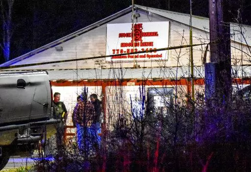 Law enforcement agents investigate the scene of a fatal robbery at Lock Stock & Barrel Shooting Range late Friday, April 8, 2022 in Coweta County, Ga., about 50 miles southwest of Atlanta. Authorities say a couple and their grandson are dead after an armed robbery at the gun range. The Grantville Police Department said via Facebook that the robbery occurred Friday evening. (Clay Neely/The Newnan Times-Herald via AP)
