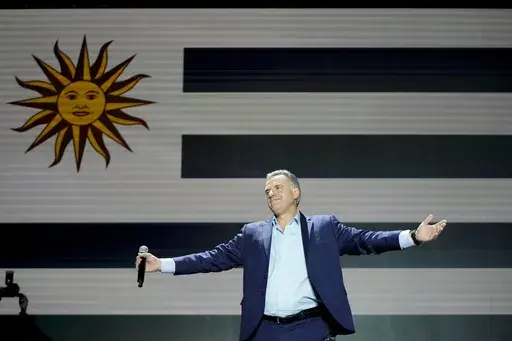 Frente Amplio presidential candidate Yamandu Orsi gets on stage outside of a hotel after general elections polls closed in Montevideo, Uruguay, Sunday, Oct. 27, 2024. (AP Photo/Natacha Pisarenko)