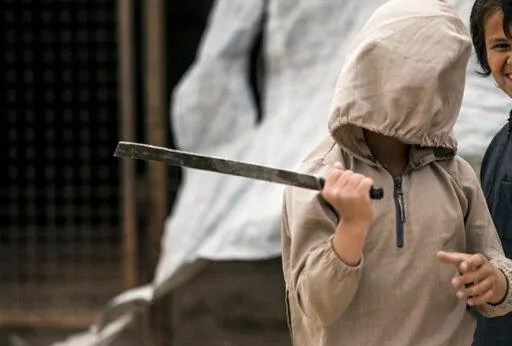 A boy plays with a broken sword, at al-Hol camp, which houses families of members of the Islamic State group, in Hasakeh province, Syria, May 1, 2021.  Hundreds of minors are believed to be holed up in Gweiran Prison, which has been at the center of an ongoing violent standoff between Islamic State group militants and U.S.-backed Kurdish fighters after IS fighters stormed the prison on Thursday, Jan. 20, 2022. A distressing series of voice notes sent by an Australian teenager from the prison in 