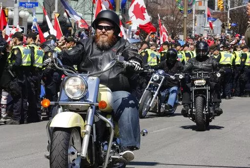 Demonstrators on motorcycles ride near the National War Memorial, part of a convoy-style protest participants are calling "Rolling Thunder" in Ottawa, Ontario, on Saturday, April 30, 2022. (Patrick Doyle/The Canadian Press via AP)
