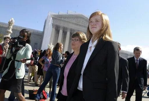 Abigail Fisher, right, who sued the University of Texas, walks outside the Supreme Court in Washington, Oct. 10, 2012. Fisher, who is white, sued after being rejected in 2008 from the University of Texas at Austin. She argued the university's policy discriminated against her because of race, in violation of the Constitution. (AP Photo/Susan Walsh, File)