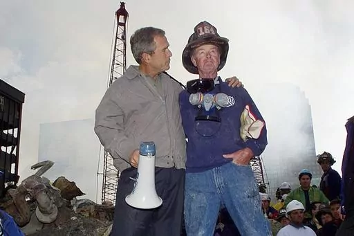 FILE — As rescue efforts continue in the rubble of the World Trade Center in New York, President George W. Bush, left, stands with New York City firefighter Bob Beckwith on a burnt fire truck in front of the World Trade Center during a tour of the devastation, Sept. 13, 2001. Beckwith, who became part of an iconic image of American unity after the Sept. 11 terrorist attacks, has died at age 91. The retired firefighter died Sunday night, Feb. 4, 2024, in hospice care after dealing with cancer i