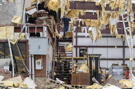 William Fraser takes photographs inside the warehouse of a damaged building of Specialty Distributors after a tornado passed through an industrial industrial park on Thursday, April 3, 2025, in Jeffersontown, Ky. (AP Photo/Jon Cherry)