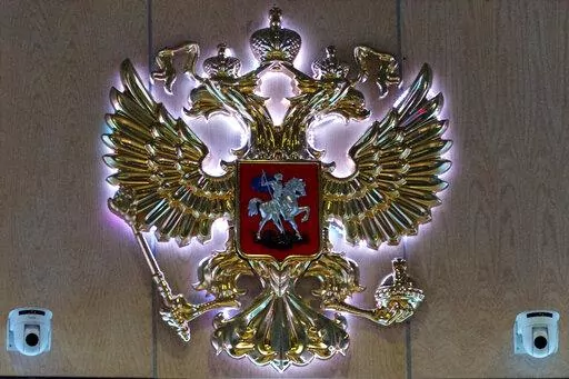 The emblem for the Russian Defense Ministry is displayed at the ministry building in Moscow, Russia on Monday, Sept. 26, 2016. On Saturday, Oct. 15, 2022, the ministry said two men fired at troops at a Russian military firing range near Ukraine, killing 11 and wounding 15 others, before getting killed. (AP Photo/Ivan Sekretarev, File)