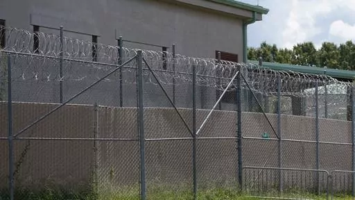 Rolls of razor wire line the top of the security fencing at the Raymond Detention Center in Raymond, Miss., Aug. 1, 2022. A man who escaped from the Mississippi jail on April 22, 2023, has been founded dead at a truck stop in New Orleans, authorities announced Tuesday, May 2. (AP Photo/Rogelio V. Solis, File)