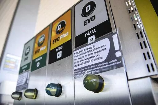 An sign at a petrol station gives information on the discount of fuel, in Budapest, Hungary, Sunday, June 12, 2022. Hungary has placed price caps on fuel and some food and imposed special taxes on industries as the government tries to ease an economic downturn and the highest inflation in nearly 25 years. (AP Photo/Anna Szilagyi)