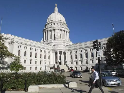 A man walks by the Wisconsin Capitol, Oct. 10, 2012, in Madison, Wis. On Wednesday, Oct. 4, 2023, a man illegally brought a loaded handgun into the Wisconsin Capitol, demanding to see Gov. Tony Evers, and returned at night with an assault rifle after posting bail, police said Thursday, Oct. 5. (AP Photo/Scott Bauer, File)