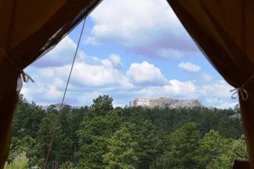 The view of Mount Rushmore located just a few miles away from Under Canvas Mount Rushmore tent cabins near Keystone, S.D. More than 10.5 million North American households took a glamping trip in 2022, up from 9.6 million in 2021. (Jim Holland/Rapid City Journal via AP, File)
