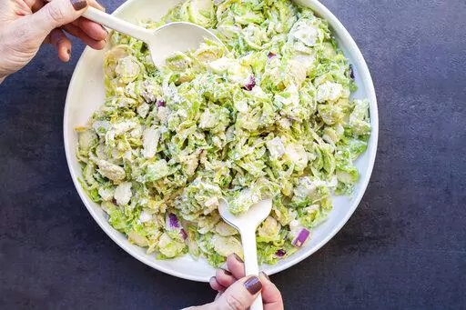 A recipe for Creamy Brussels Sprouts Slaw, with a mayonnaise-based dressing spiked with citrus juice, onions, mustard, and Parmesan cheese, appears in New York in January 2018. (Carrie Crow via AP)