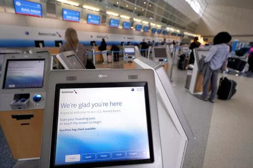 Travelers use kiosk to check their bags as they arrive to travel out of Dallas/Fort Worth International airport Tuesday, Nov. 22, 2022, in Grapevine, Texas.  Pandemic rebooking issues drove many air passengers to book directly with airlines instead of third-party travel sites. While ancillary fees have become a major part of airline revenue over the past 15 years, airlines have more recently ramped up efforts to drive revenue from add-on fees. (AP Photo/Tony Gutierrez)