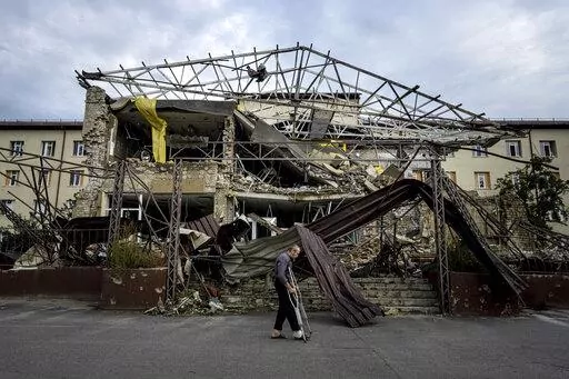 A patient walks past the surgery department which was destroyed after a Russian attack at the hospital in Izium, Ukraine, Saturday, Sept. 17, 2022. Medical staff at the Izium hospital in eastern Ukraine are fighting the memories of six deadly months under Russian occupation. They also are looking darkly ahead at the coming months without electricity. (AP Photo/Evgeniy Maloletka)