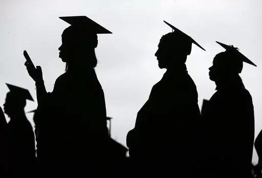 In this May 17, 2018, file photo, new graduates line up before the start of the Bergen Community College commencement at MetLife Stadium in East Rutherford, N.J.  A deadline is fast approaching for teachers, librarians, nurses and others who work in public service to apply to have their student loan debt forgiven. New figures from the U.S. Department of Education show 145,000 borrowers have had the remainder of their debt canceled through the Public Service Loan Forgiveness program. (AP Photo/Se