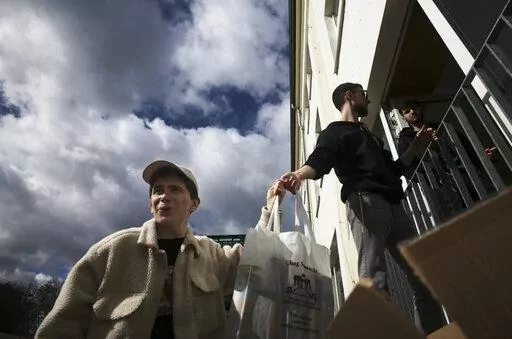 From left, Danya, 21, Gabriel, 21 and Borden, 17 all refugees from Odesa, Ukraine help to deliver bags with food to needy people during preparations for the celebration of Jewish Passover at the Chabad Jewish Education Center in Berlin, Germany, Thursday, April 7, 2022. Rabbis and Jewish organizations are working round the clock within Ukraine, Eastern Europe and other parts of Europe to make sure that Jews who remain in Ukraine and refugees who have fled as far away as Israel are able to celebr