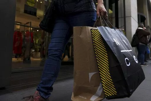 A shopper carries bags down Fifth Avenue on Black Friday, Nov. 25, 2022, in New York. Holiday sales rose as shoppers showed some resilience during the most important shopping season despite surging prices on everything from food to rent. (AP Photo/Julia Nikhinson, File )